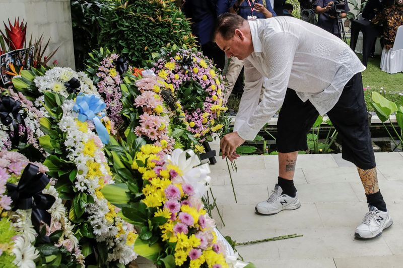 © Reuters. Australian Bali bombing survivor, Andrew Csabi lays a flower during the commemoration of the 20th anniversary of the Bali bombing that killed 202 people, mostly foreign tourists, including 88 Australians and seven Americans, at the Australian Consulate in Denpasar, Bali, Indonesia, October 12, 2022. Johannes P. Christo/Pool via REUTERS