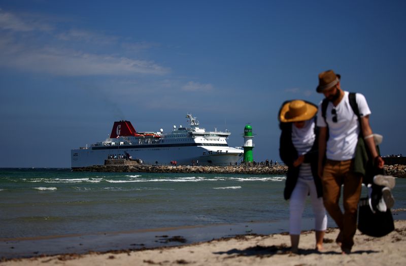 &copy; Reuters. FILE PHOTO: A couple walks along the beach of the Baltic Sea as a cruise ship arrives in Warnemuende, Germany, June 4, 2022. REUTERS/Lisi Niesner