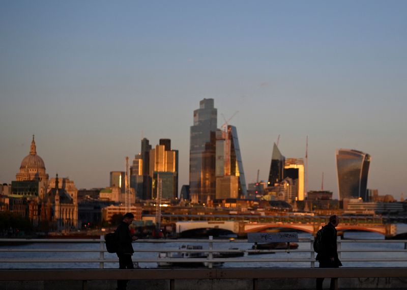 &copy; Reuters. FILE PHOTO: People cross Waterloo Bridge during the evening rush-hour with skyscrapers of the City of London financial district seen behind in London, Britain, October 10, 2022. REUTERS/Toby Melville/File Photo