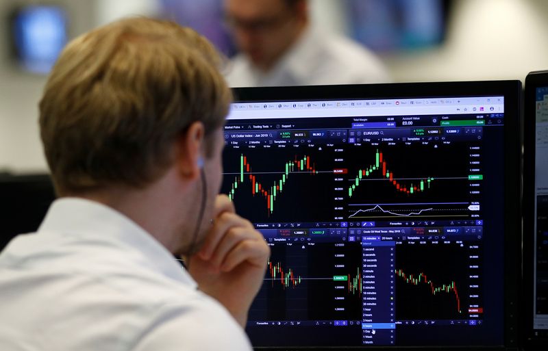 &copy; Reuters. A financial trader works at their desk at CMC Markets in the City of London, Britain, April 11, 2019.  REUTERS/Peter Nicholls