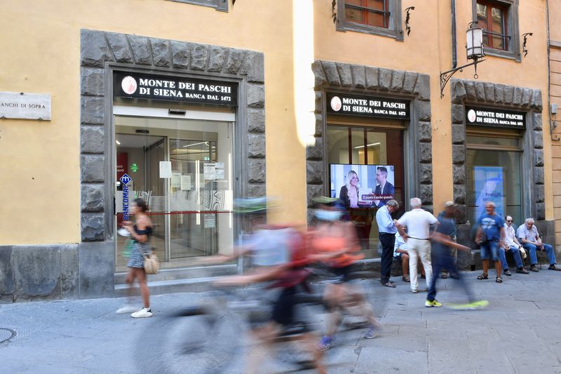 &copy; Reuters. FILE PHOTO: People pass in front of a branch of Monte dei Paschi di Siena (MPS), the oldest bank in the world, which is facing massive layoffs as part of a planned business merger, in Siena, Italy, August 11 2021. REUTERS / Jennifer Lorenzini