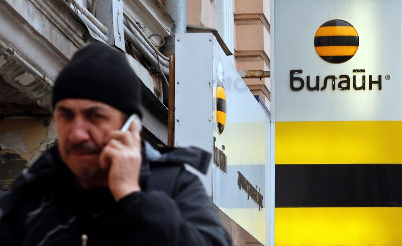 &copy; Reuters. FILE PHOTO: A man speaks on the phone near an office of Beeline, the brand owned by mobile phone operator Vimpelcom, in Moscow, November 12, 2014. REUTERS/Maxim Shemetov/File Photo