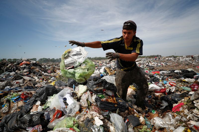 © Reuters. Diego, 19, looks through heaps of waste at a landfill for cardboard, plastic and metal, which he sells while working 12-hour shifts, as Argentina faces one of the world's highest inflation rates, set to top 100% this year, in Lujan, on the outskirts of Buenos Aires, Argentina October 5, 2022. REUTERS/Agustin Marcarian