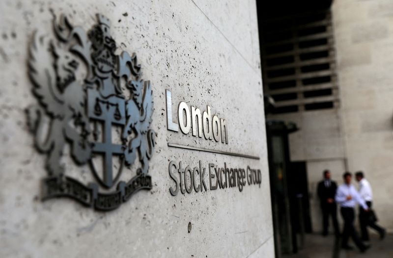 &copy; Reuters. Des piétons sortent et entrent à la Bourse de Londres. /Photo d'archives/REUTERS/Neil Hall
