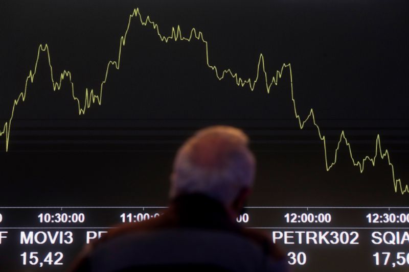 &copy; Reuters. FILE PHOTO: A man looks at an electronic board showing the recent fluctuations of market indices on the floor of Brazil's B3 Stock Exchange in Sao Paulo, Brazil October 28, 2021. REUTERS/Amanda Perobelli/File Photo