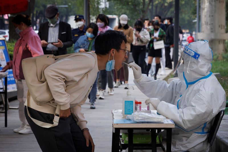 &copy; Reuters. FILE PHOTO: A man gets a swab at a nucleic acid testing station set up to trace possible coronavirus disease (COVID-19) outbreaks in Beijing, China, October 7, 2022. REUTERS/Thomas Peter