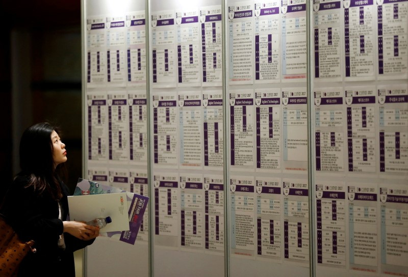 &copy; Reuters. FILE PHOTO: A woman looks at recruiting information during a job fair in Seoul, South Korea, April 12, 2017.  REUTERS/Kim Hong-Ji/File Photo 