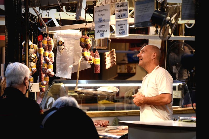 &copy; Reuters. FILE PHOTO: A butcher helps customers in a market as inflation in Argentina hits its highest level in years, causing food prices to spiral, in Buenos Aires, Argentina April 12, 2022.  Picture taken April 12, 2022. REUTERS/Mariana Nedelcu/File Photo