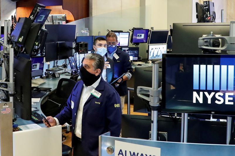 © Reuters. FILE PHOTO: Traders wearing masks work, on the first day of in-person trading since the closure during the outbreak of the coronavirus disease (COVID-19) on the floor at the New York Stock Exchange (NYSE) in New York, U.S., May 26, 2020. REUTERS/Brendan McDermid/