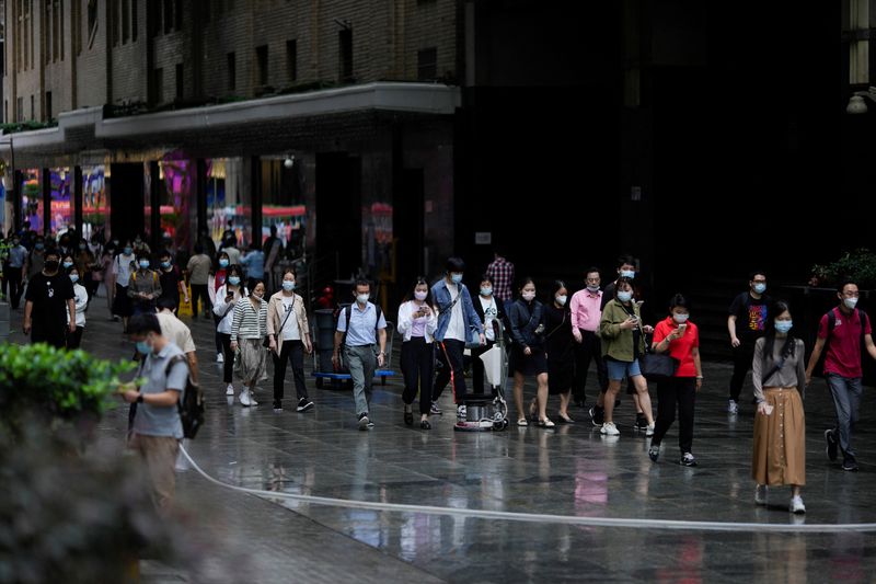 &copy; Reuters. FILE PHOTO: People wearing protective face masks walk on a street, following the coronavirus disease (COVID-19) outbreak, in Shanghai, China, September 28, 2022. REUTERS/Aly Song