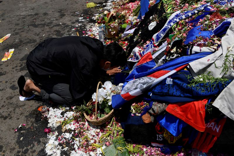 &copy; Reuters. FILE PHOTO: A man kneels at the Lion Statue of Kanjuruhan Stadium as he pays his condolences for the victims of a riot and stampede following a soccer match between Arema vs Persebaya Surabaya in Malang, East Java province, Indonesia, October 4, 2022, in 