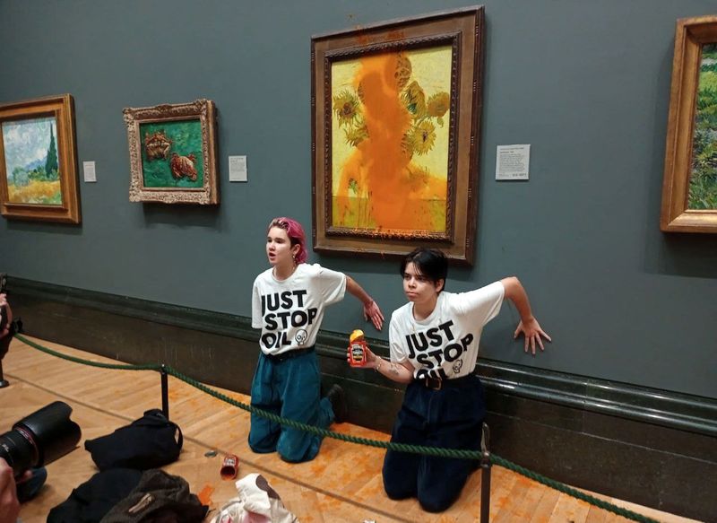 &copy; Reuters. Des membres du mouvement écologiste "Just Stop Oil" collent leurs mains au mur après avoir jeté de la soupe sur "Les Tournesols" de Vincent Van Gogh à la National Gallery de Londres. /Photo prise le 14 octobre 2022/REUTERS/Just Stop Oil