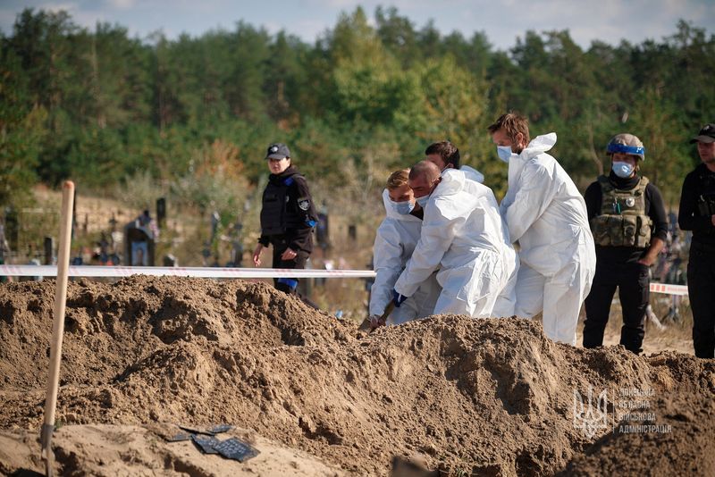 &copy; Reuters. FILE PHOTO: Forensic technicians and officers work at what appears to be a mass grave declared by regional governor Pavlo Kyrylenko as found in the town of Lyman, recently retaken by the Ukrainian army, in this undated handout image obtained by Reuters Oc