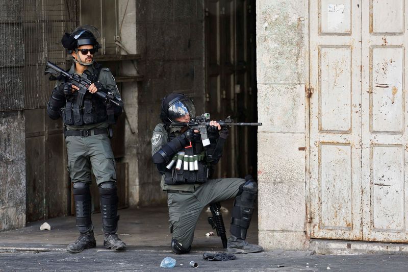 © Reuters. FILE PHOTO: A member of the Israeli forces aims his weapon amid clashes with Palestinians during a protest in Hebron in the Israeli-Occupied West Bank October 14, 2022. REUTERS/Mussa Qawasma