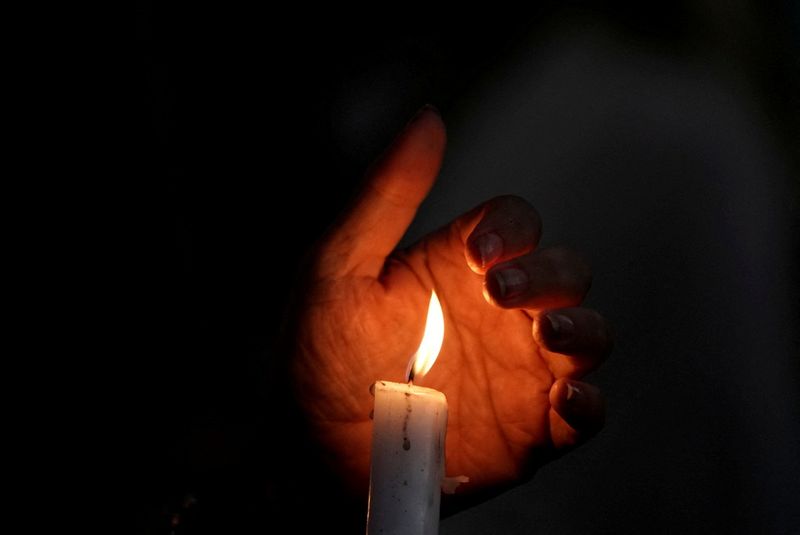 &copy; Reuters. FILE PHOTO: A demonstrator cups their hand around a lit candle at a protest following the death of a young Iranian Kurdish woman, Mahsa (Zhina) Amini, outside the Wilshire Federal Building in Los Angeles, California, U.S., September 22, 2022. REUTERS/Bing