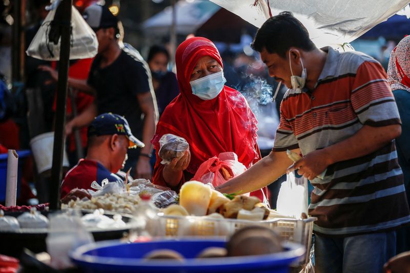 &copy; Reuters. FILE PHOTO: A woman wearing a protective mask to prevent the spread of the coronavirus disease (COVID-19) shops at a traditional market in Jakarta, Indonesia, March 1, 2021. REUTERS/Willy Kurniawan