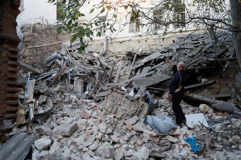 © Reuters. A local resident takes pictures of a building heavily damaged by a Russian missile strike, amid Russia’s attack on Ukraine, in Mykolaiv, Ukraine October 18, 2022. REUTERS/Valentyn Ogirenko