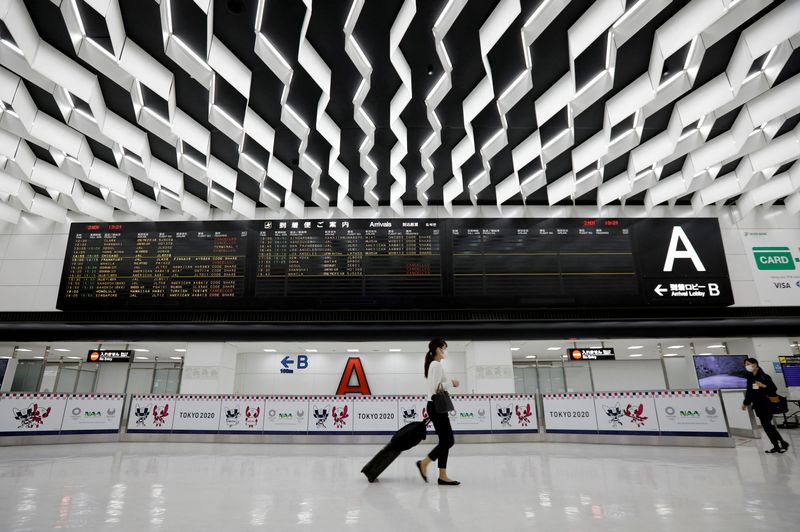 © Reuters. FILE PHOTO: Women wearing protective face masks walk past the arrival zone at Narita international airport amid the coronavirus disease (COVID-19) outbreak, in Narita, east of Tokyo, Japan November 2, 2020. REUTERS/Issei Kato/File Photo