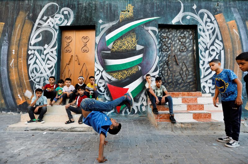 &copy; Reuters. طفل فلسطيني يؤدي رقصة البريك دانس في الشارع في مخيم النصيرات في غزة يوم 14 أكتوبر تشرين الأول 2022. تصوير: إبراهيم أبو مصطفى - رويترز.