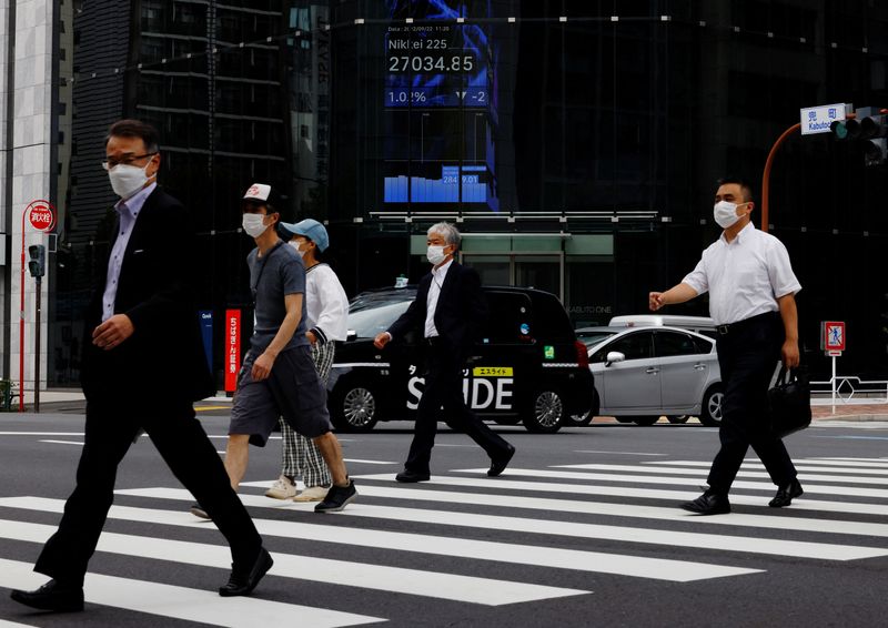 &copy; Reuters. People pass by an electronic screen showing Japan's Nikkei share price index inside a commercial building in Tokyo, Japan September 22, 2022. REUTERS/Kim Kyung-Hoon