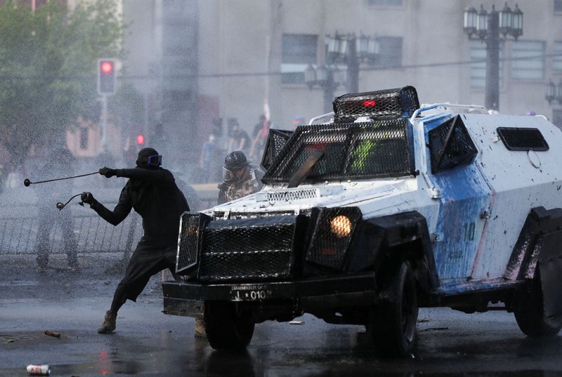 &copy; Reuters. A demonstrator hits an armored police vehicle during a rally on the third anniversary of the protests and riots that rocked the country in 2019, in Santiago, Chile, October 18, 2022. REUTERS/Ivan Alvarado