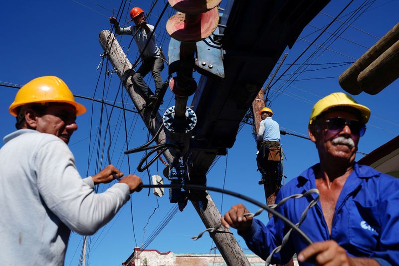 &copy; Reuters. Operarios arreglan un poste eléctrico dañado durante el huracán Ian en Pinar del Río, Cuba, el 4 de octubre, 2022. REUTERS/Alexandre Meneghini