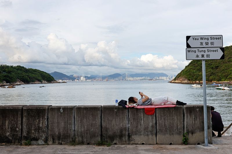 © Reuters. A woman lies near the seashore, on Peng Chau island in Hong Kong, China August 19, 2022. REUTERS/Tyrone Siu   