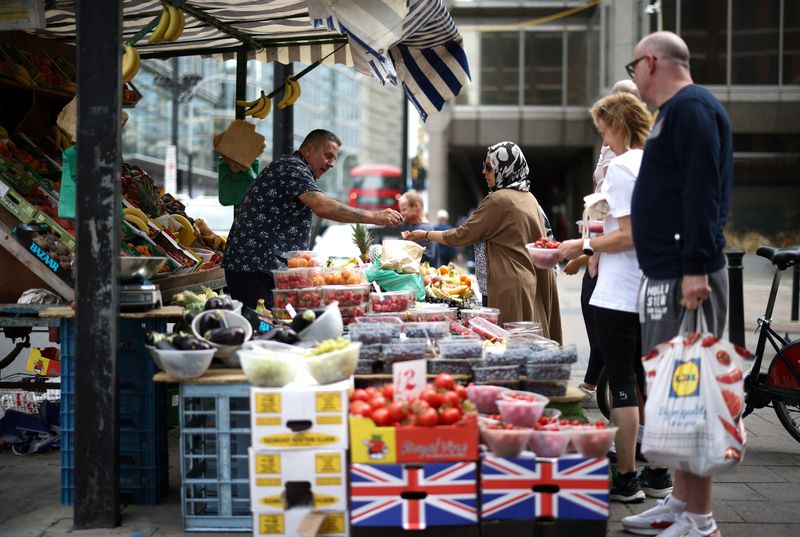 © Reuters. FILE PHOTO: A person buys produce from a fruit and vegetable market stall in central London, Britain, August 19, 2022. REUTERS/Henry Nicholls/File Photo