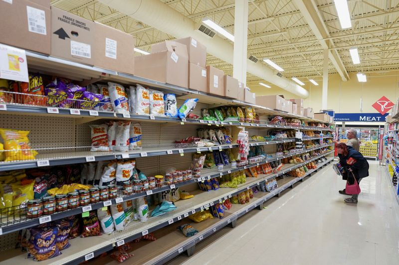 &copy; Reuters. FILE PHOTO: Two individuals look at a popular trend for Atlantic Canada, (storm) chips in the Dominion grocery store before the arrival of Hurricane Fiona, in Corner Brook, Newfoundland, Canada September 23, 2022. REUTERS/John Morris