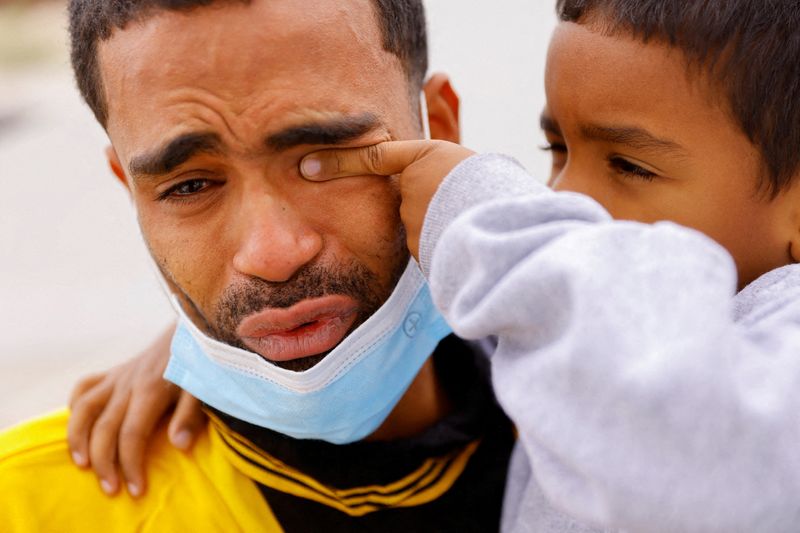 © Reuters. FILE PHOTO: Saul, 4, wipes the tears of his father Franklin Pajaro, after they were expelled from the U.S. and sent back to Mexico under Title 42, near the Paso del Norte International border bridge, in Ciudad Juarez, Mexico October 17, 2022. REUTERS/Jose Luis Gonzalez/File Photo