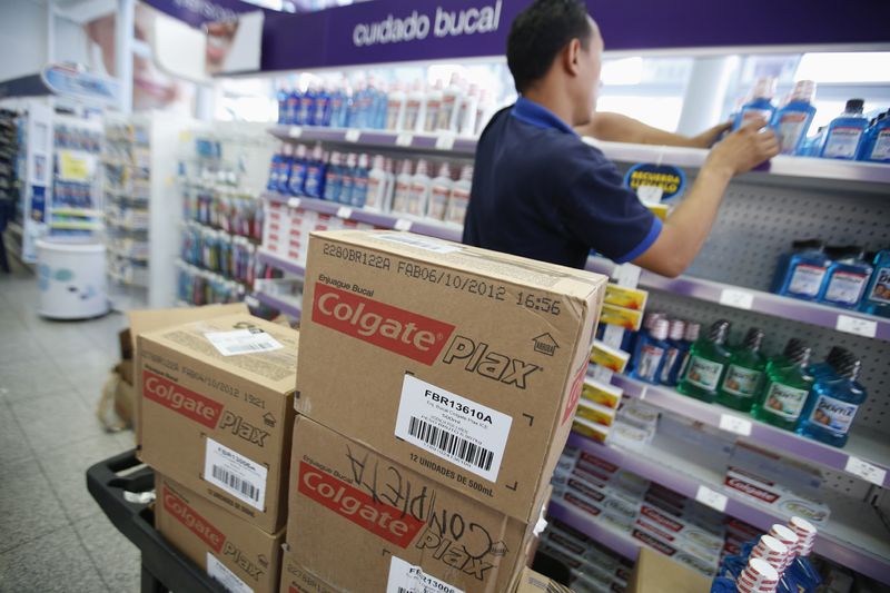© Reuters. FILE PHOTO: A worker arranges Colgate products on a shelf at a supermarket in Caracas February 12, 2013. REUTERS/Jorge Silva