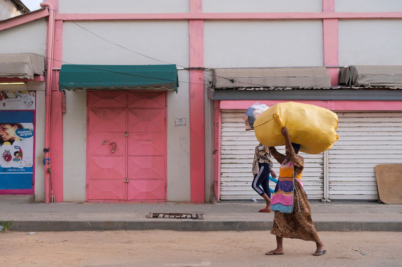 &copy; Reuters. People walk in front of closed shops as traders lock up their stores in protest of Ghana's worsening economic conditions in Accra, Ghana October 19, 2022. REUTERS/Francis Kokoroko