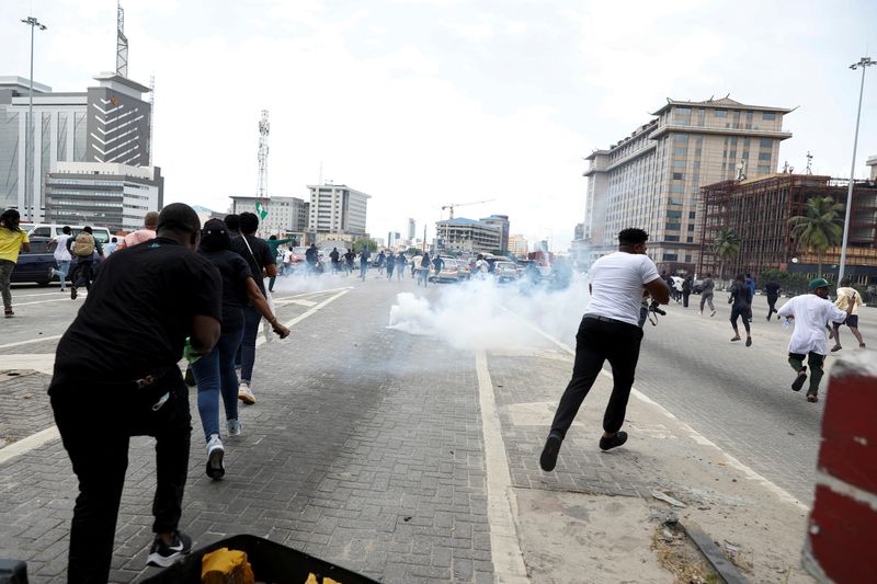 &copy; Reuters. محتجون يفرون من غاز مسيل للدموع أطلقته الشرطة لتفريق مسيرة في لاجوس يوم الخميس. تصوير: تيميلاد أديلاجا - رويترز. 