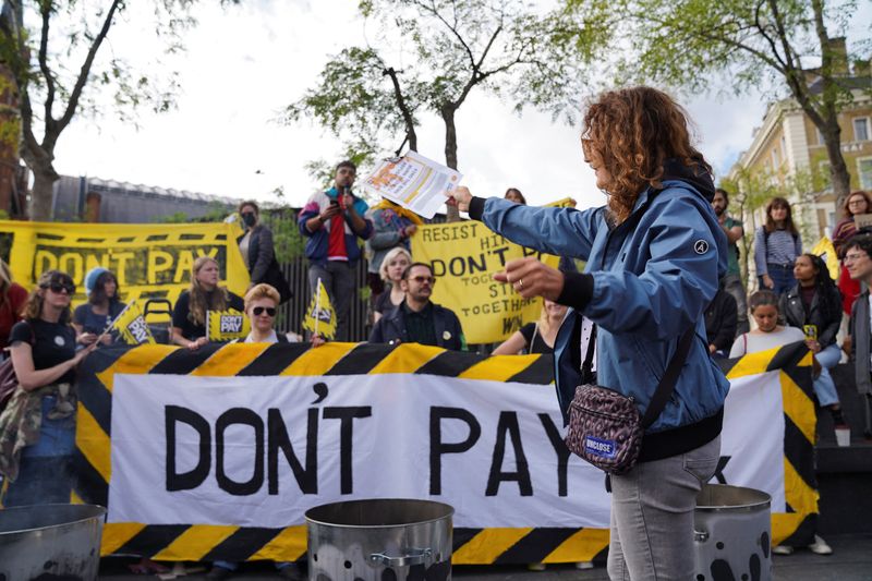 &copy; Reuters. FILE PHOTO: A volunteer burns a bill in the protest against raising costs of living, at Kings Cross in London, Britain October 1, 2022. REUTERS/Maja Smiejkowska