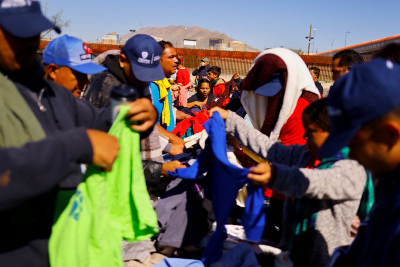 © Reuters. Venezuelan migrants, some expelled from the U.S. to Mexico under Title 42 and others who have not crossed yet, receive used clothing by members of a Christian church near the Paso del Norte International border bridge, in Ciudad Juarez, Mexico October 20, 2022. REUTERS/Jose Luis Gonzalez