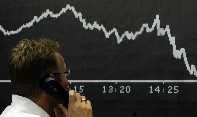 © Reuters. A trader talks on the phone as he stands in front of the DAX board at the Frankfurt stock exchange September 16, 2008.   REUTERS/Alex Grimm