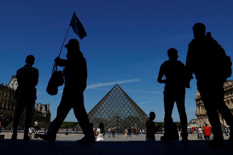 &copy; Reuters. Imagem de arquivo: turistas caminham perto da Pirâmide de Vidro do Museu do Louvre em Paris. REUTERS/Gonzalo Fuentes/Arquivo