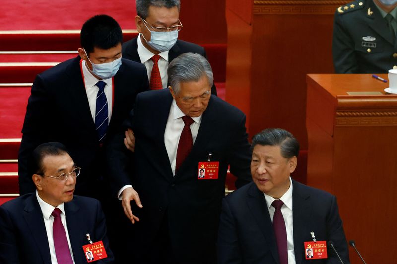 © Reuters. Former Chinese president Hu Jintao leaves his seat next to Chinese President Xi Jinping and Premier Li Keqiang, during the closing ceremony of the 20th National Congress of the Communist Party of China, at the Great Hall of the People in Beijing, China October 22, 2022. REUTERS/Tingshu Wang