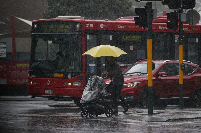 &copy; Reuters. FILE PHOTO: A pedestrian pushing a baby pram crosses a flooding intersection as heavy rains affect Sydney, Australia, October 6, 2022.  REUTERS/Loren Elliott/File Photo