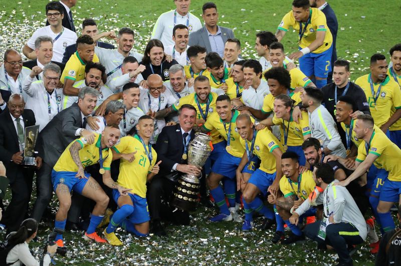 © Reuters. FILE PHOTO: Soccer Football - Copa America Brazil 2019 - Final - Brazil v Peru - Maracana Stadium, Rio de Janeiro, Brazil - July 7, 2019    Brazil's President Jair Bolsonaro and Brazil players celebrate winning the Copa America with the trophy   REUTERS/Sergio Moraes/File Photo