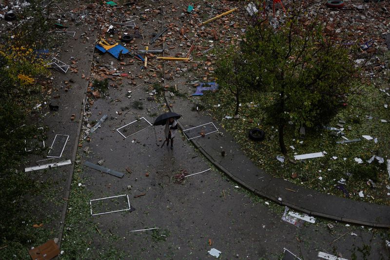 © Reuters. A local resident walks at a backyard of a residential building heavily damaged by a Russian missile attack in Mykolaiv, Ukraine October 23, 2022.  REUTERS/Valentyn Ogirenko