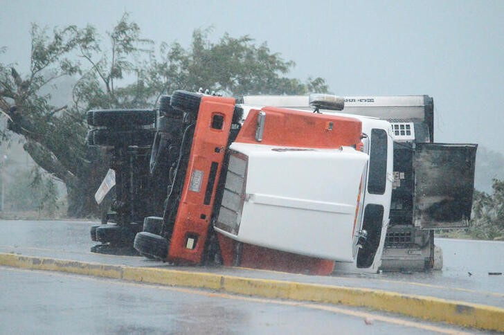 &copy; Reuters. ハリケーン「ロズリン」が２３日にメキシコの太平洋岸に上陸後、熱帯暴風雨に変わり、大雨や洪水をもたらした。写真は、ハリケーンによる強風によって高速道路上で横転したトラック。