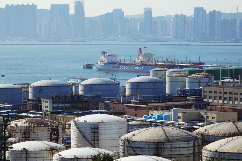 © Reuters. FILE PHOTO: A China Ocean Shipping Company (COSCO) vessel is seen near oil tanks at the China National Petroleum Corporation (CNPC)'s Dalian Petrochemical Corp in Dalian, Liaoning province, China October 15, 2019. REUTERS/Stringer 