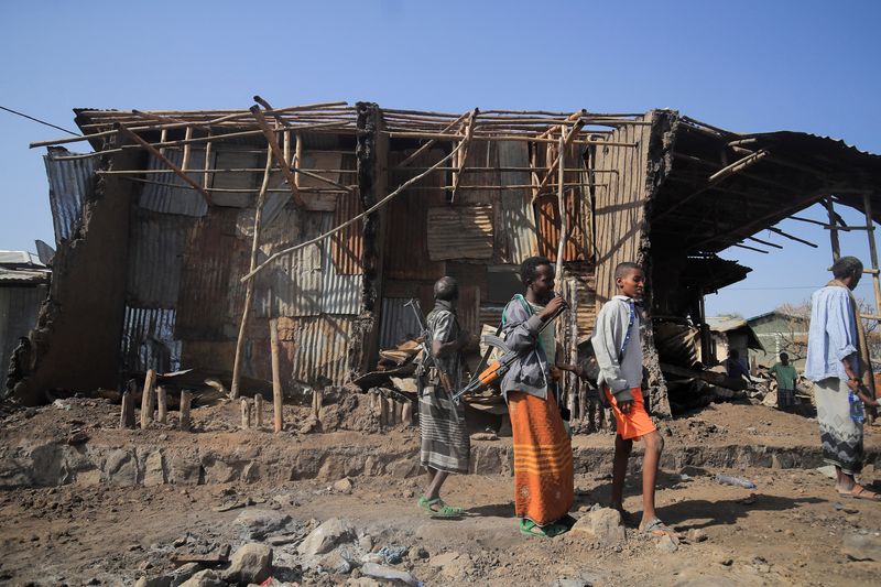&copy; Reuters. FOTO DE ARCHIVO: Residentes y milicianos junto a casas destruidas por un ataque aéreo durante la lucha entre las Fuerzas de Defensa Nacional de Etiopía (ENDF) y las fuerzas del Frente de Liberación del Pueblo de Tigray (TPLF) en la ciudad de Kasagita, 