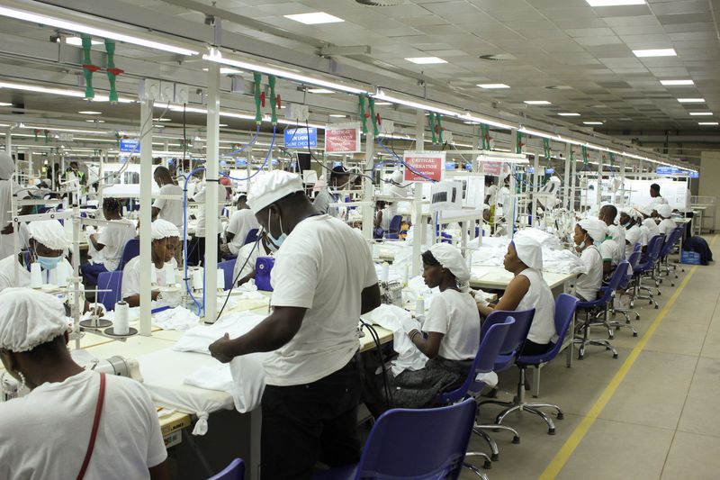 &copy; Reuters. FILE PHOTO: People work at a shirt-making factory in the Glo-Djigbe Industrial Zone (GDIZ) in Abomey-Calavi, Benin October 13, 2022. REUTERS/Coffi Seraphin Zounyekpe