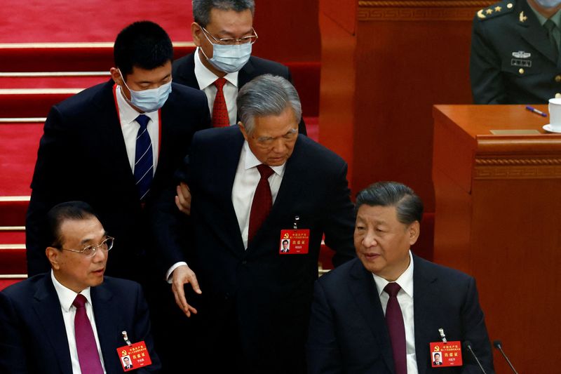 © Reuters. FILE PHOTO: Former Chinese president Hu Jintao leaves his seat next to Chinese President Xi Jinping and Premier Li Keqiang, during the closing ceremony of the 20th National Congress of the Communist Party of China, at the Great Hall of the People in Beijing, China October 22, 2022. REUTERS/Tingshu Wang/File Photo