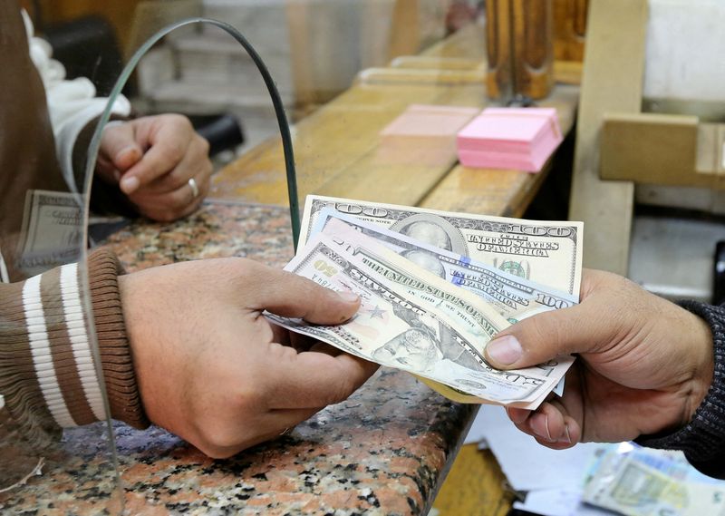 &copy; Reuters. Pessoa troca dólares por libras egípcias em casa de câmbio no Cairo
27/12/2016
REUTERS/Mohamed Abd El Ghany/File Photo