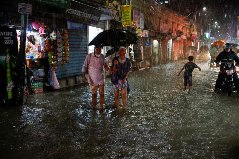 &copy; Reuters. People wade through a flooded street amid continuous rain before the Cyclone Sitrang hits the country in Dhaka, Bangladesh, October 24, 2022. REUTERS/Mohammad Ponir Hossain
