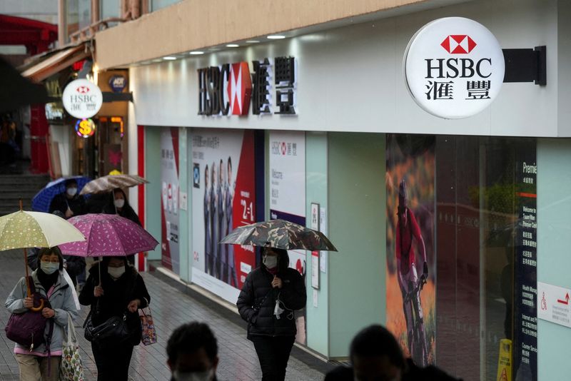 &copy; Reuters. FOTO DE ARCHIVO: Peatones con mascarillas tras el brote de la enfermedad por coronavirus (COVID-19), pasan por delante de una sucursal bancaria del HSBC en Hong Kong, China el 22 de febrero de 2022. REUTERS/Lam Yik/File Photo