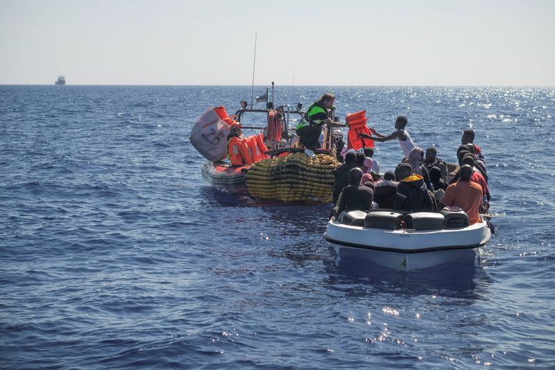 &copy; Reuters. أفراد من طاقم سفينة أوشن فايكنج يقدمون سترات نجاه للمهارجين على متن زورق مكدس بالمهاجرين في البحر المتوسط يوم الثلاثاء. صورة لرويترز (يحظر إ